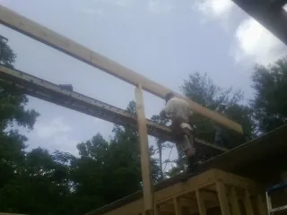 Carpenter setting a ridge beam over a new addition frame — Ice Dam Removal by Roofing Brothers in Isanti