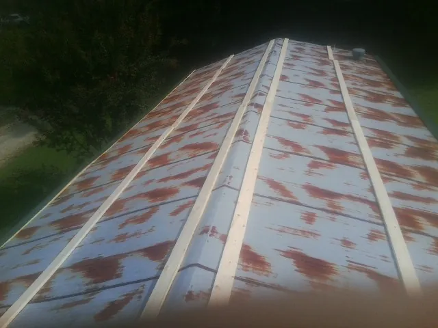 Rusted metal roof panels with new wood purlins before replacement — Storm Damage Roof Repair in Isanti by Roofing Brothers
