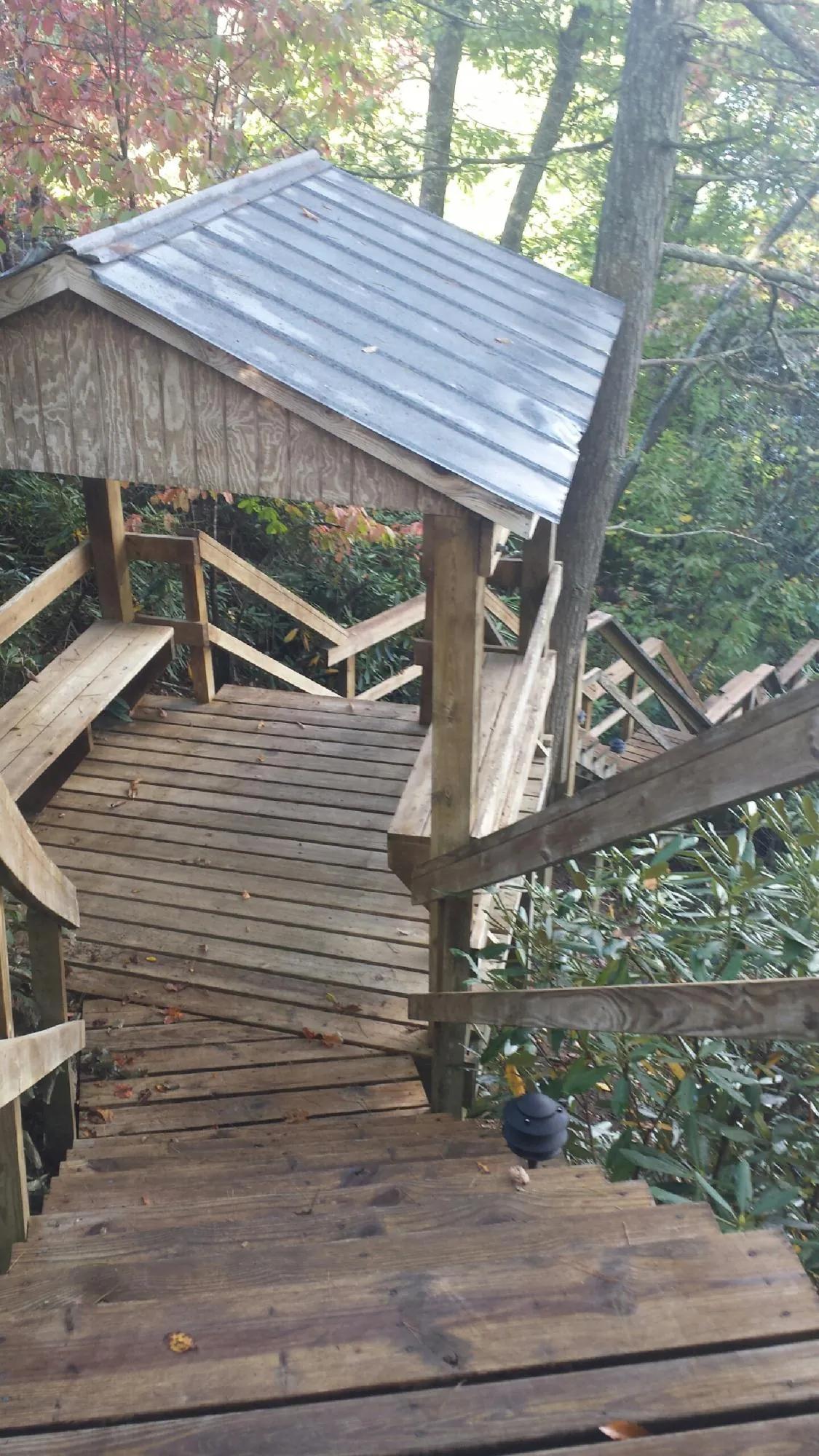 Metal roofed shelter over wooden steps on a wooded walkway — Skylight Repair & Installation work by our crew in Isanti