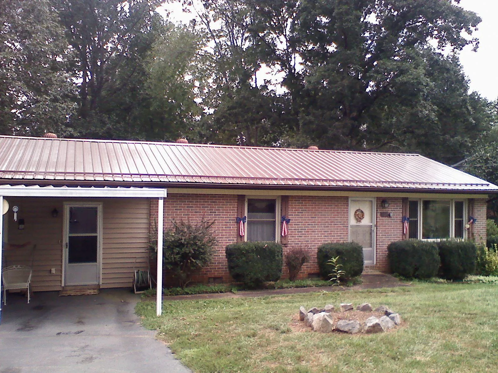 Bronze metal roof and carport on a brick ranch home — Roof Repair work by our crew in Isanti