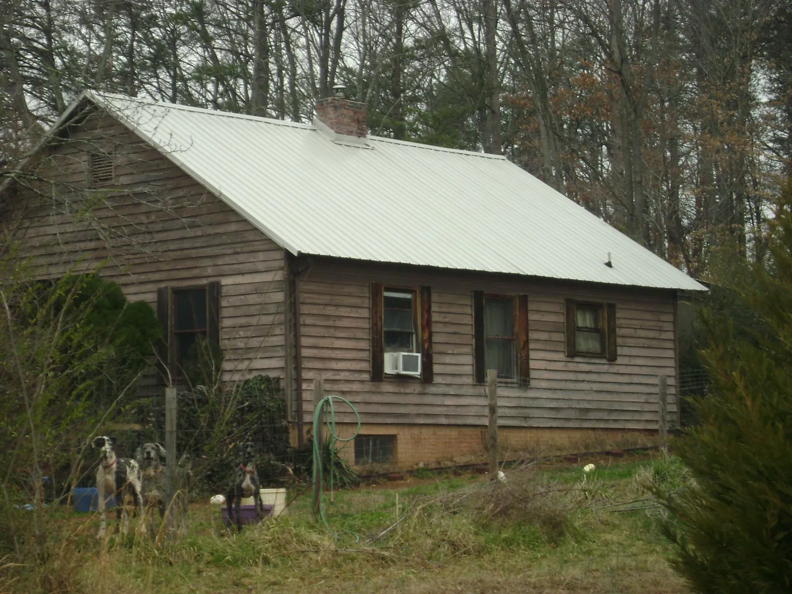 White metal roof on an old wood sided farmhouse, from a Metal Roof Installation job in Isanti